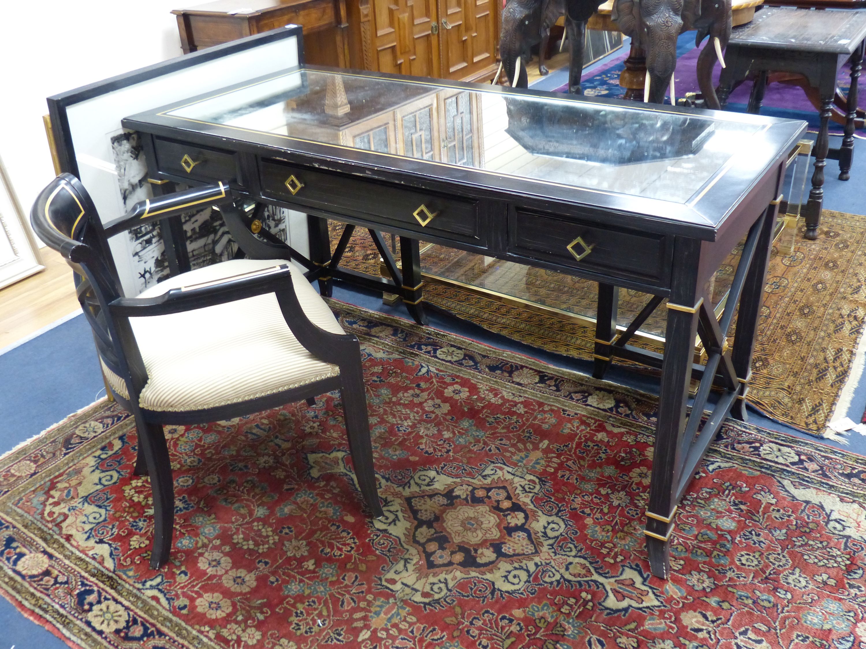 A Regency style ebonised mirrored dressing table, width 139cm, depth 64cm, height 75cm and elbow chair